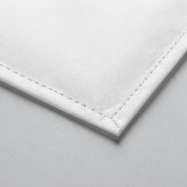 Macro shot of a clean, tight stitch on a spunbond bag edge, neutral gray background, studio lighting