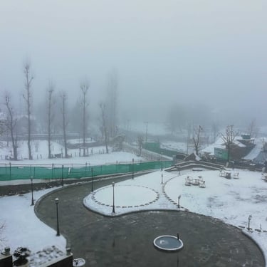 Kashmir trip details - A serene, snow-covered resort courtyard in Gulmarg captured during a quiet winter morning.