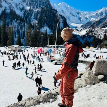 Manali trip details - An explorer in winter gear looking out over the snowy activity hub of Solang Valley