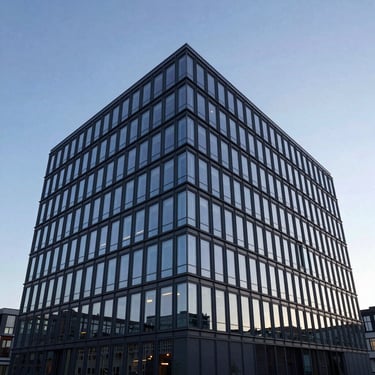 Wide angle shot of a multi-story modern office building in Sweden featuring a structural glass facade reflecting a soft blue twilight sky