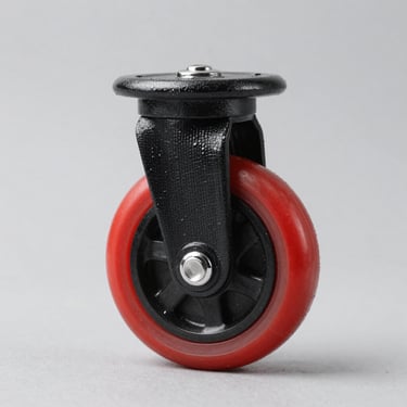 Studio product shot of a medium-duty industrial caster wheel with red polyurethane tread on black nylon center, clean light grey background.