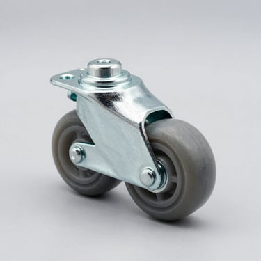 Studio product shot of a grey thermoplastic rubber light-duty swivel caster wheel, zinc-plated steel mounting plate, high-contrast side-lighting, isolated on a clean light-grey background.