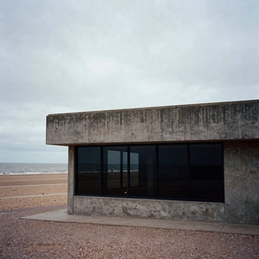 Moody film photograph of a brutalist concrete storefront on the Margate coast, overcast sky, high contrast