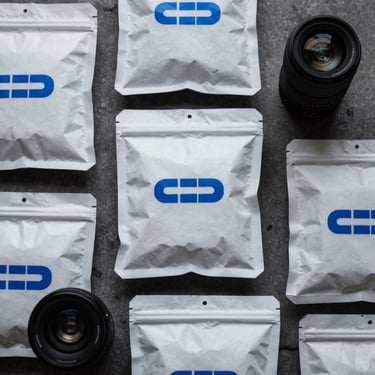 Clean flat-lay of custom corporate merch packages with electric blue branding elements, moody key light, 35mm lens