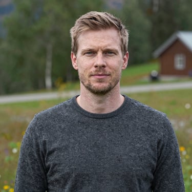 A smiling customer shaking hands with a mechanic inside Autofix Garage, with a repaired car in the background.