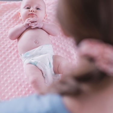 Baby lying on a pink blanket during a Rock & Roll Baby massage class in Radwinter near Saffron Walden