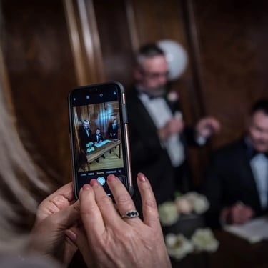 guest taking a picture of the newly-weds signing the wedding register