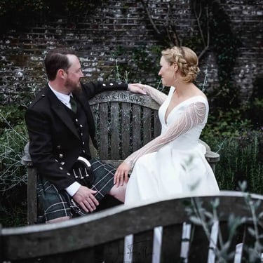 newly-weds sitting on a park bench
