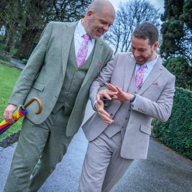 two grooms looking at their wedding rings