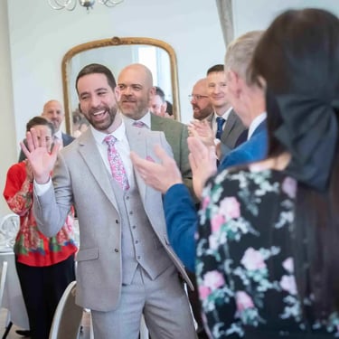 two grooms meeting guest at teh wedding at Pembroke Lodge Richmond
