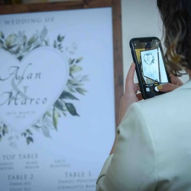 someone taking a photo of wedding table sign