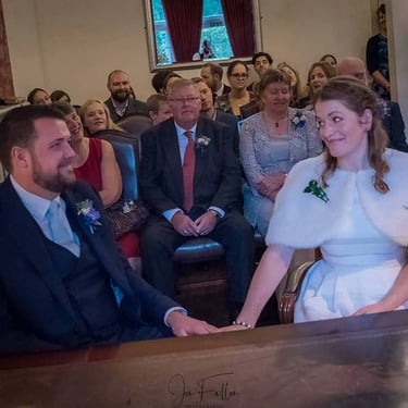 Newly weds holding hands in the Garden Room in Southwark Registry Office