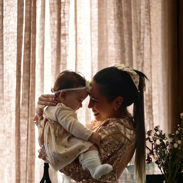 Mamá sosteniendo a su bebé en brazos durante sesión en Bogotá — fotografía TheLens.
