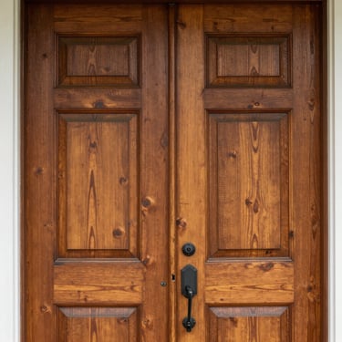 Close-up detail of historic North Carolina home craftsmanship, warm wood grain of a front door, soft natural daylight.