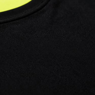 Macro shot of premium heavy cotton t-shirt fabric texture, pitch black, high-contrast lighting