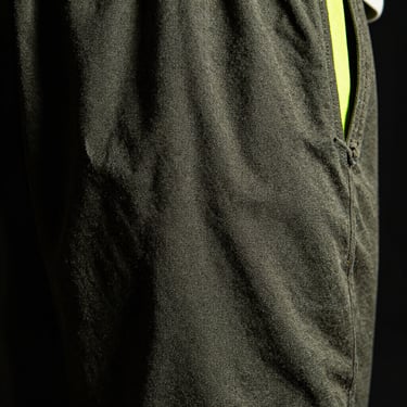Industrial workwear pants fabric close-up, heavy canvas texture, high-contrast lighting