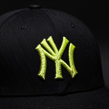 Streetwear cap close-up, high-quality embroidery detail, moody atmosphere