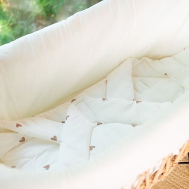 Detailopname van een duurzame rotan wieg passend bij een botanisch babykamer thema