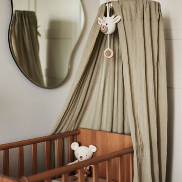 Detail van een luxe boho-stijl sluier voor het babybedje in een aardetinten interieur
