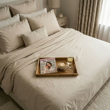 Rustig bed met dienblad erop met een kop koffie en een tijdschrift met de naam Baby Mamas Must Haves