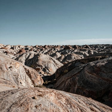 Wide panoramic raw development lot in California, high-contrast rocky terrain, low horizon, harsh midday sun, expansive sky.
