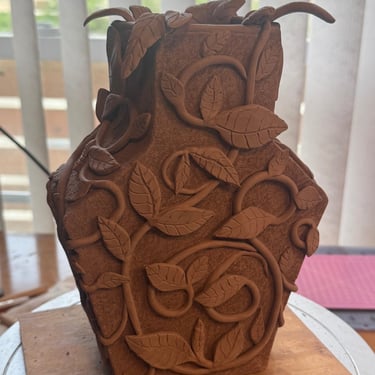 Pottery vase with vines and leaves unglazed
