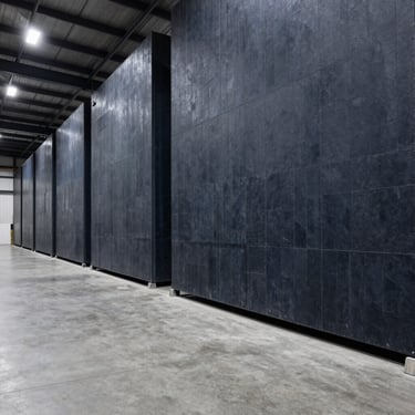 Architectural shot of a high-security warehouse interior, clean concrete floors, slate tones, premium industrial aesthetic, 35mm