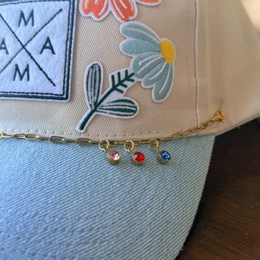 close up of blue mama hat with birthstone charm chain
