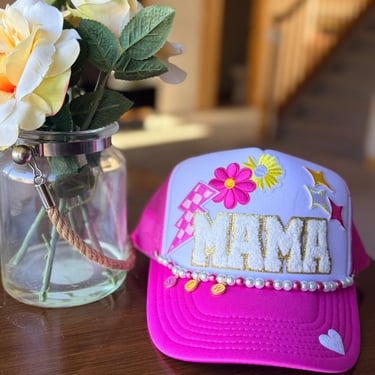 pink mama hat on table with flowers
