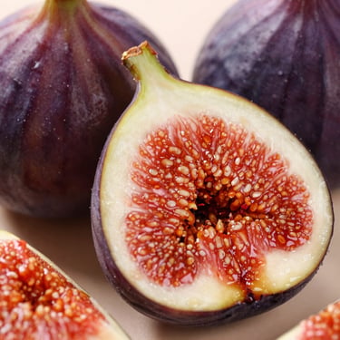 Macro close-up of fresh organic figs, sliced open to reveal rich red pulp, glistening textures, soft natural lighting