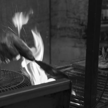 Las manos del vendedor de chorizos guardan el calor del fogón