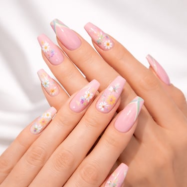 Pink coffin nails with floral nail art and white daisy designs for a spring manicure.
