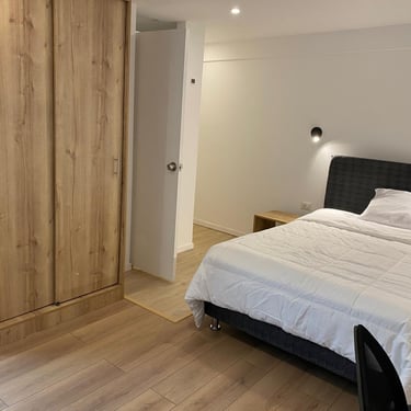 Moderna habitacion, con velador y luz de pared, en hotel hospedaje condor palace en huayllay pasco