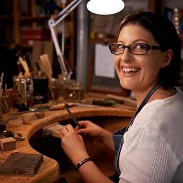 Artesana muy feliz elaborando joyería artesanal hecha a mano en estudio mexicano