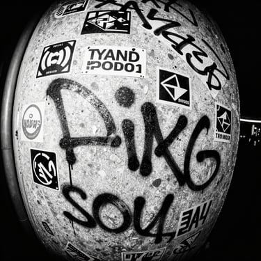 Extreme close-up of a concrete wall covered in raw marker graffiti and stickers, high contrast black and white photocopy texture.