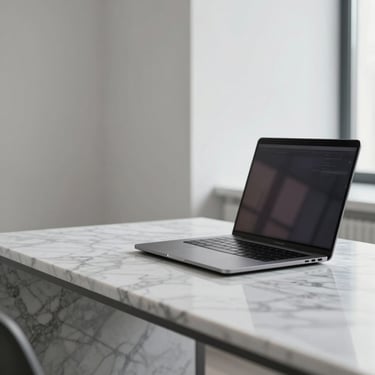 A clean architectural view, bright neutral daylight with cool undertones, focusing on a modern marble workspace with a sleek laptop and steel reflections.