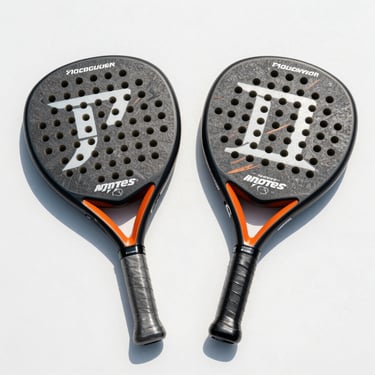Overhead shot of two premium padel rackets side by side on a clean white surface under sharp natural daylight, grip tape and frame detail visible