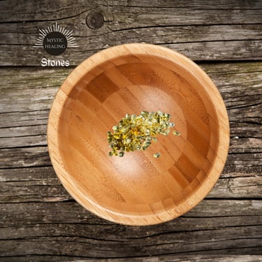Small yellow citrine healing crystals in a bamboo wooden bowl on a rustic timber background.