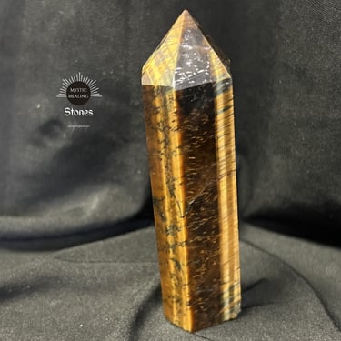 Polished tiger's eye crystal point tower with golden brown bands for healing and protection.
