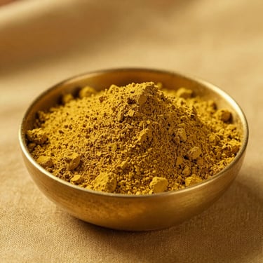 Warm mustard yellow pigment powder in a polished brass bowl, side-light casting soft shadows, macro grain, 35mm