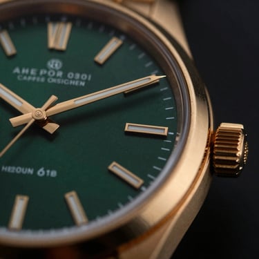 Tight macro shot of a gold watch bezel and dark green dial, dramatic side lighting, luxury aesthetic