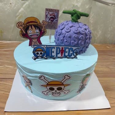 Un pastel de cumpleaños de One Piece azul claro con Monkey D. Luffy, una fruta Gomu Gomu no Mi púrpu