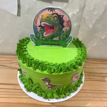 Pastel de cumpleaños de dinosaurio verde personalizado con un adorno T-Rex y detalles de glaseado de