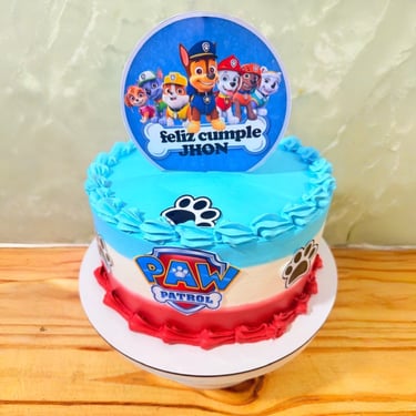Pastel de cumpleaños personalizado de la Patrulla Canina para Jhon con glaseado azul y rojo con ador