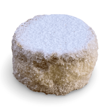 A round Spanish polvoron shortbread cookie coated in white powdered sugar against a black background.