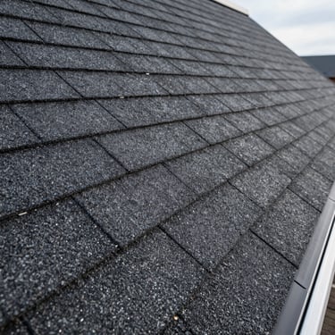 Close-up of perfectly laid architectural asphalt shingles on a steep roof ridge, clean flashing details