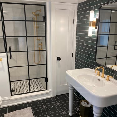 Smiling homeowner standing beside newly tiled bathroom floor with elegant patterns.