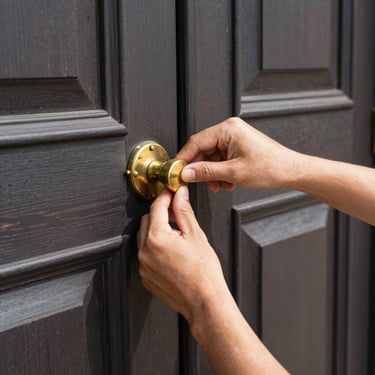 Close-up of a craftsman's hands precisely adjusting a heavy brass handle on a dark oak door, warm natural light casting sharp architectural shadows.