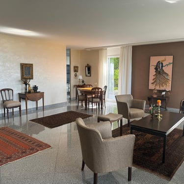 Séjour lumineux avec salon et salle à manger, mobilier élégant et grandes ouvertures sur l’extérieur.