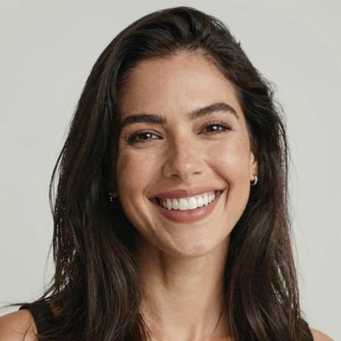 Portrait of a confident woman smiling warmly in a modern office setting.